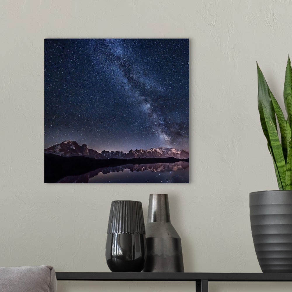 A modern room featuring A beautiful view of the Milky Way galaxy and the stars above a mountain range, with a lake reflec...
