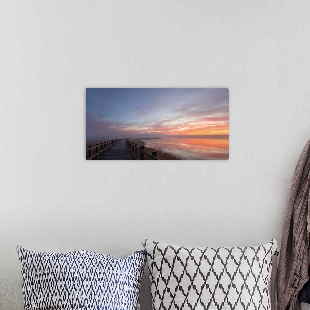 A bohemian room featuring Pastel sunlight on clouds at dawn over a bridge in Denmark.