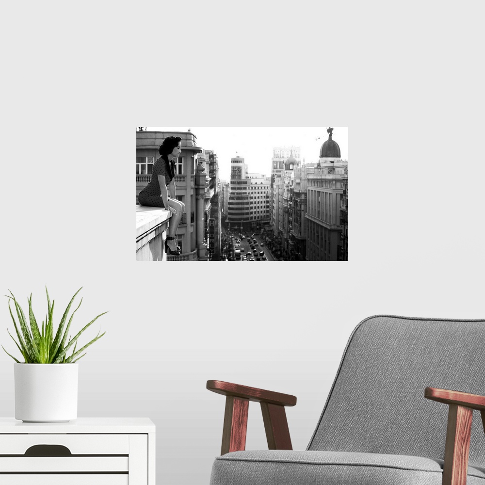 A modern room featuring A woman sits on a ledge overlooking  the streets of Madrid.
