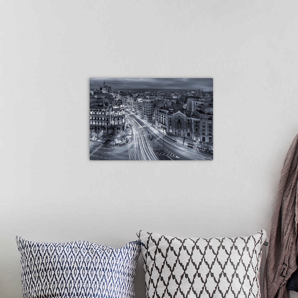 A bohemian room featuring A photograph of Madrid with light trails covering the roads, Spain.