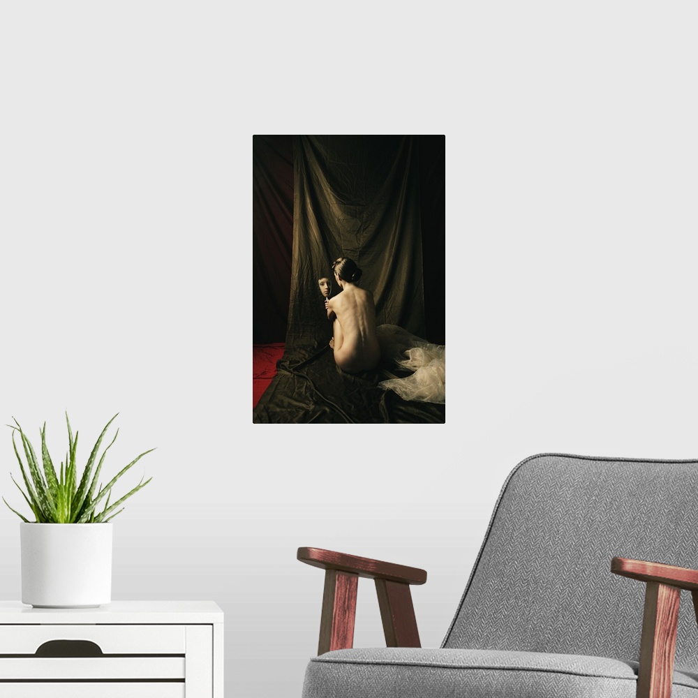A modern room featuring Antique style fine art photograph of a nude woman sitting with her back to the camera looking at ...