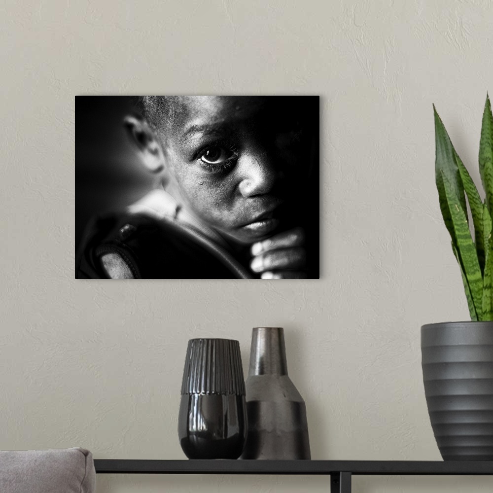 A modern room featuring Portrait of a young boy with large eyes and a concerned expression.