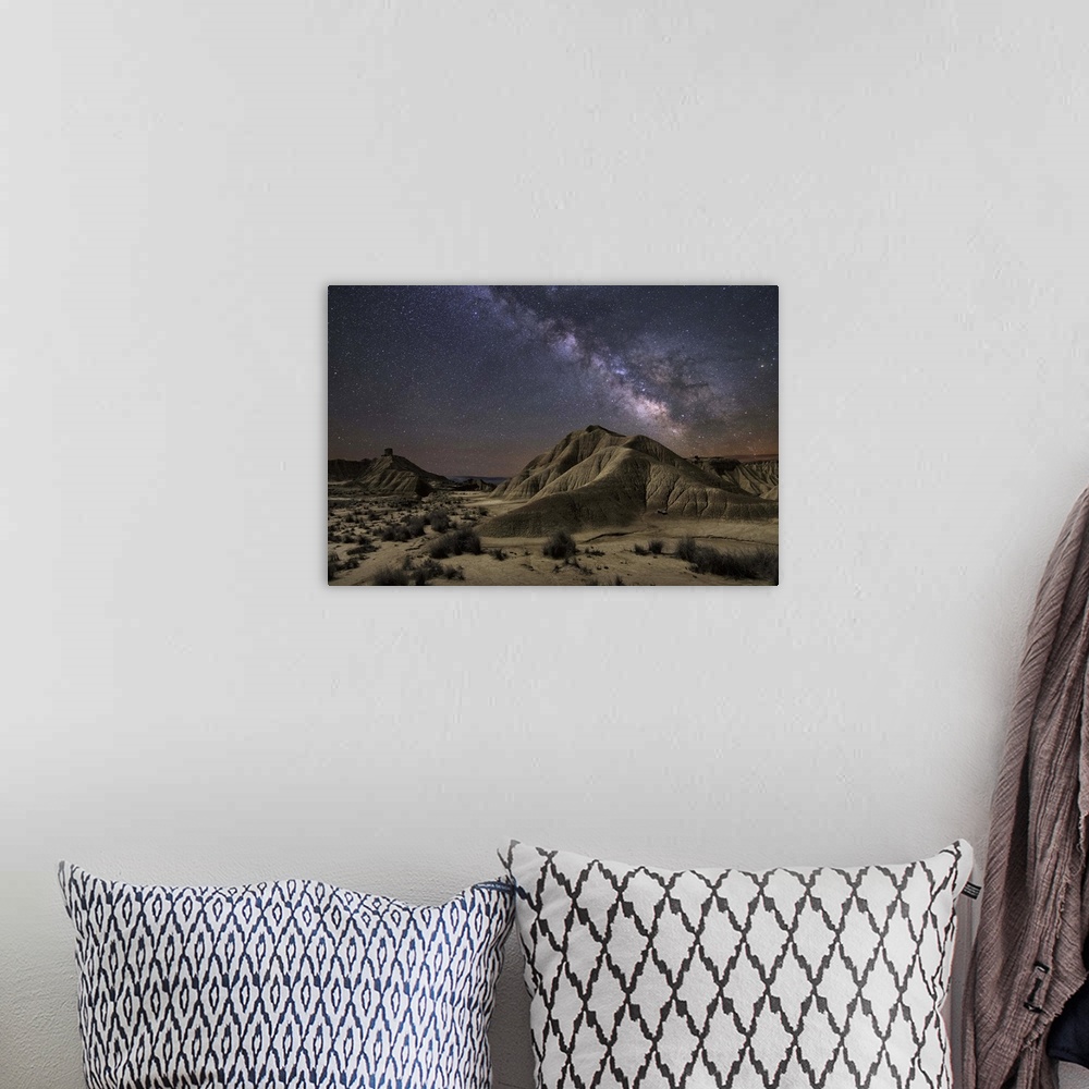 A bohemian room featuring The Milky Way galaxy illuminated over a rocky desert landscape.