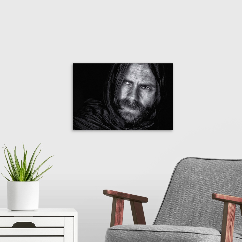 A modern room featuring Portrait of a man with a beard and long hair, wearing a hood.