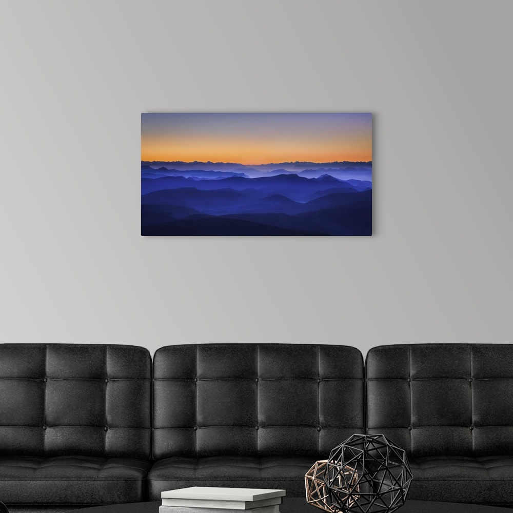 A modern room featuring Ethereal mountain valley in gradating blue tones under a sunset sky.