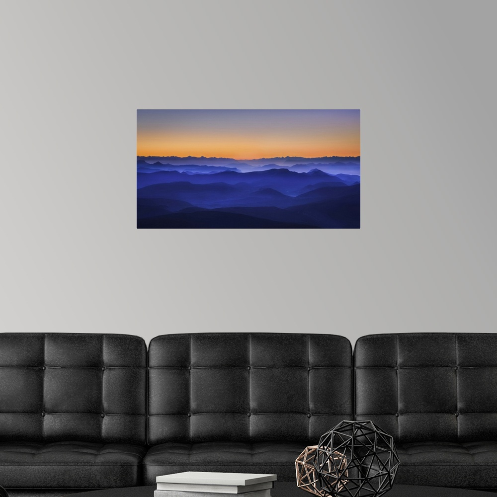 A modern room featuring Ethereal mountain valley in gradating blue tones under a sunset sky.