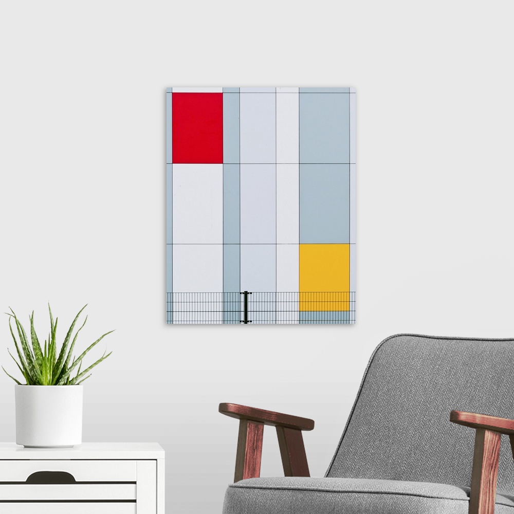A modern room featuring The facade of a building with red and yellow panels resembling a Mondrian painting.