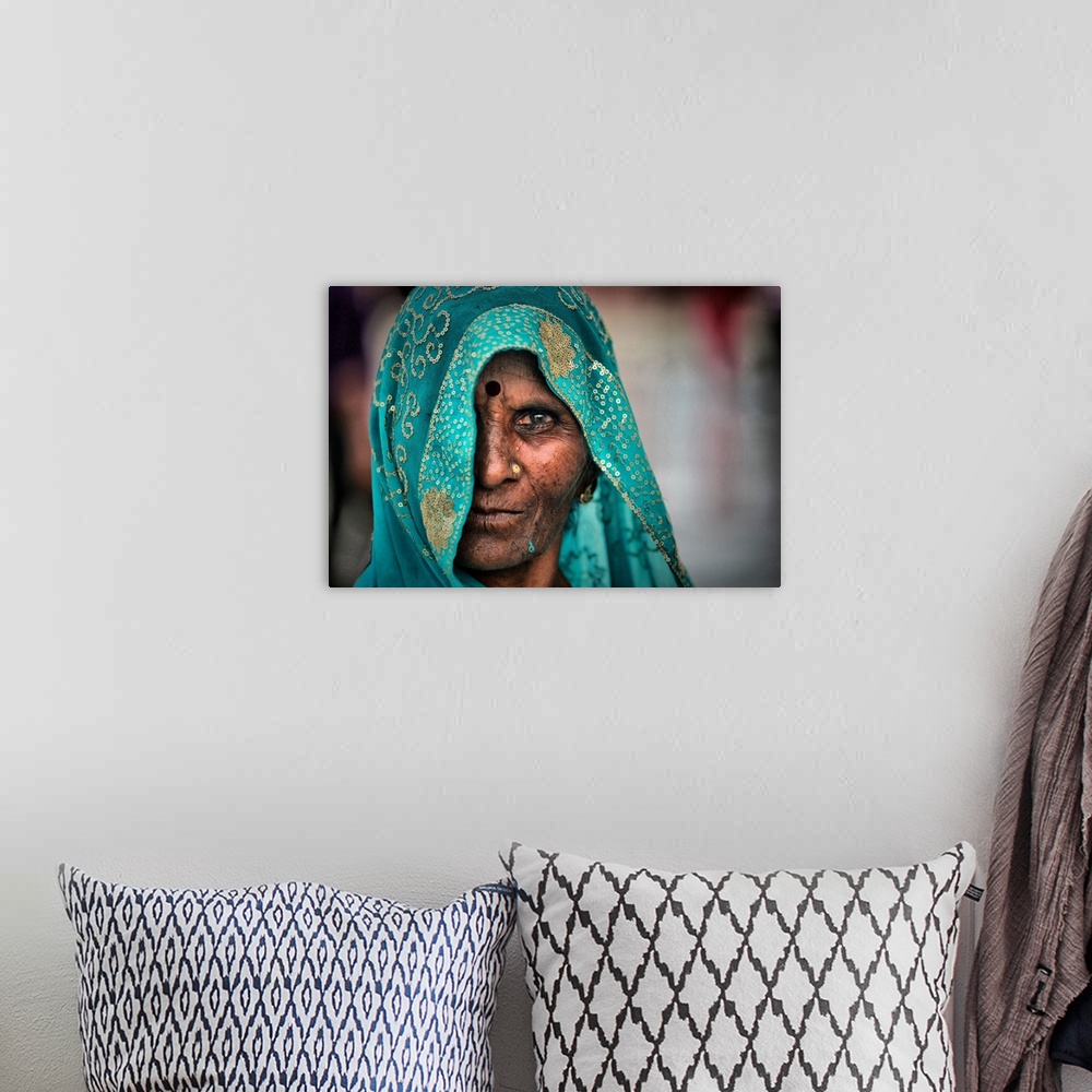 A bohemian room featuring Portrait of an elderly woman wearing a turquoise embroidered veil.