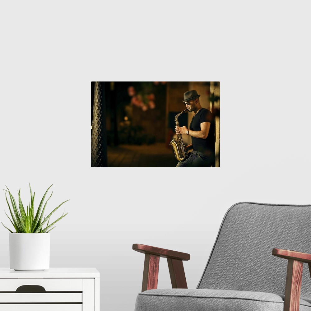 A modern room featuring A man playing a saxophone in the street at night.