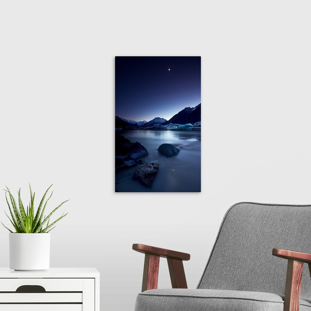 A modern room featuring View of the moon over a river and snowy mountains in the evening, New Zealand.