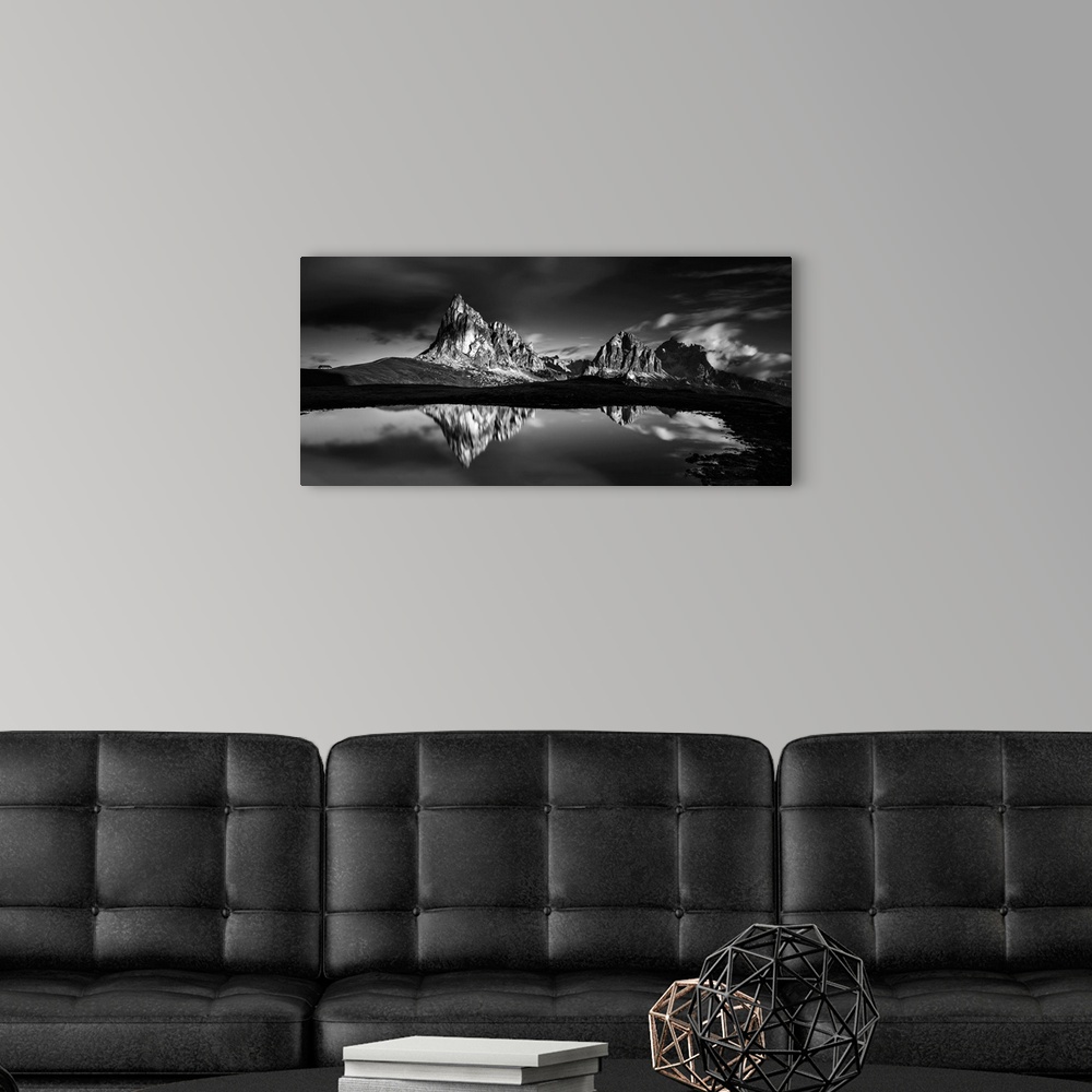 A modern room featuring Black and white panoramic landscape photograph of the Dolomites, Italy with reflections on the lake.