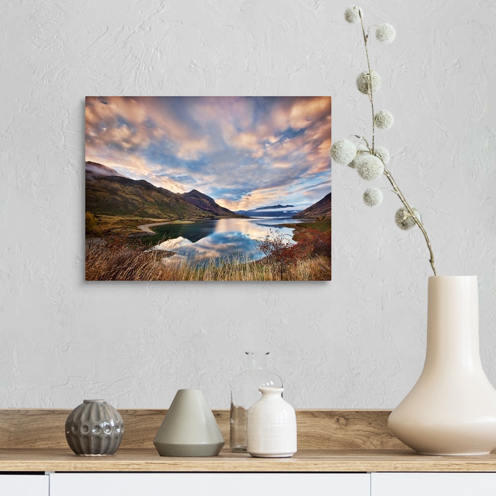 A farmhouse room featuring Dramatic clouds hang over a mountain lake scene.
