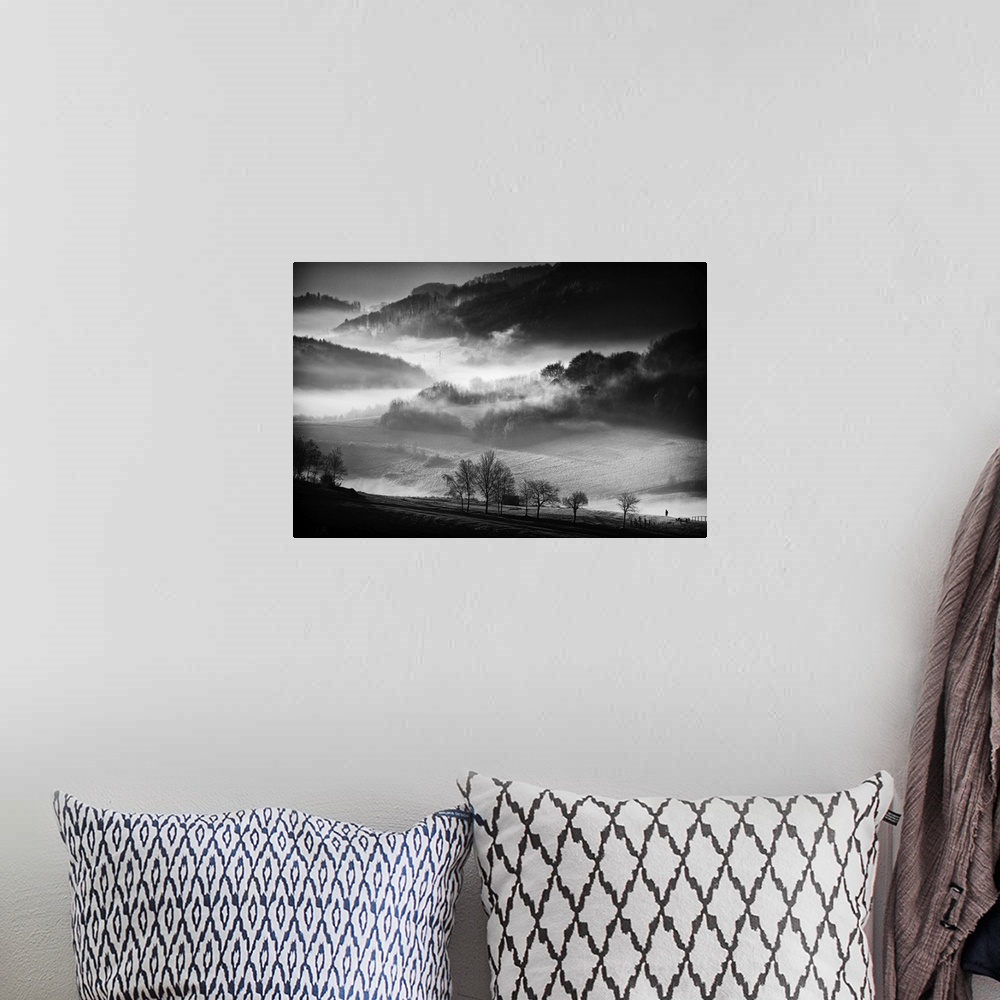 A bohemian room featuring Black and white image of a foggy valley in the morning.