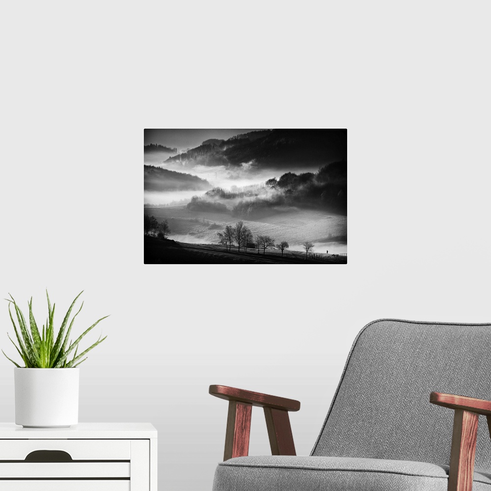 A modern room featuring Black and white image of a foggy valley in the morning.