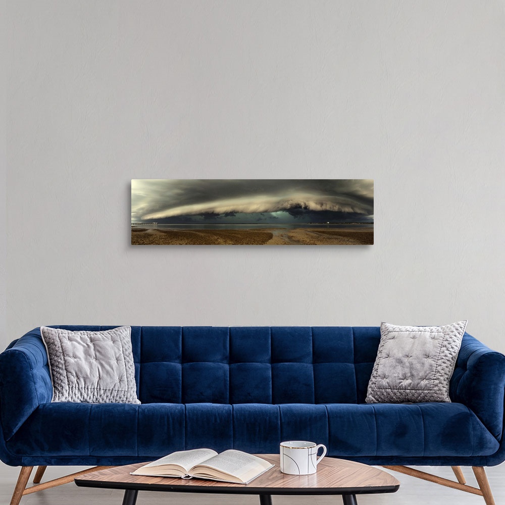 A modern room featuring Panoramic image of a beach with a thick wall of stormclouds approaching.