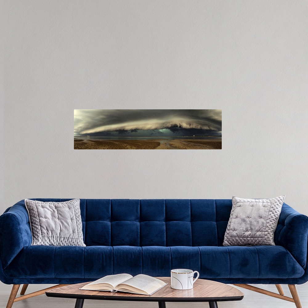 A modern room featuring Panoramic image of a beach with a thick wall of stormclouds approaching.