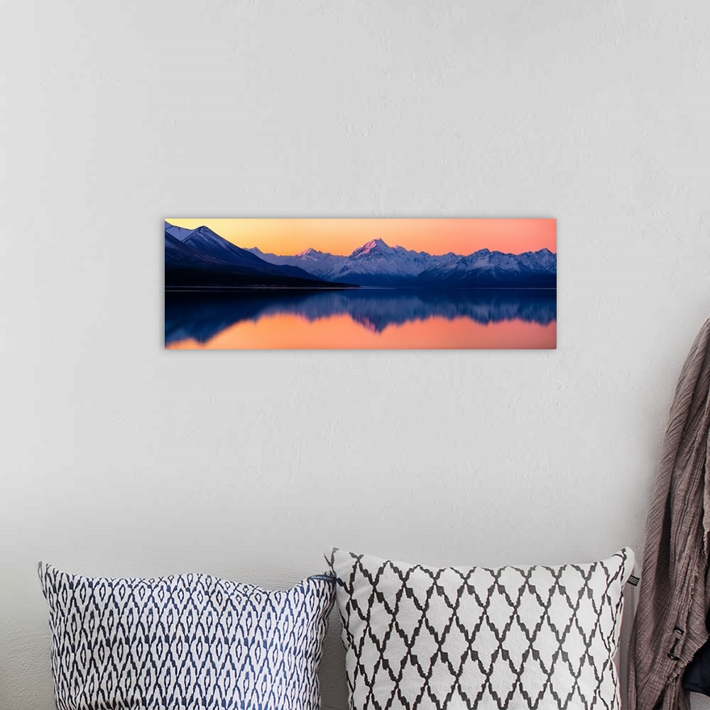 A bohemian room featuring Mount Cook at sunset reflecting in a lake below, New Zealand.