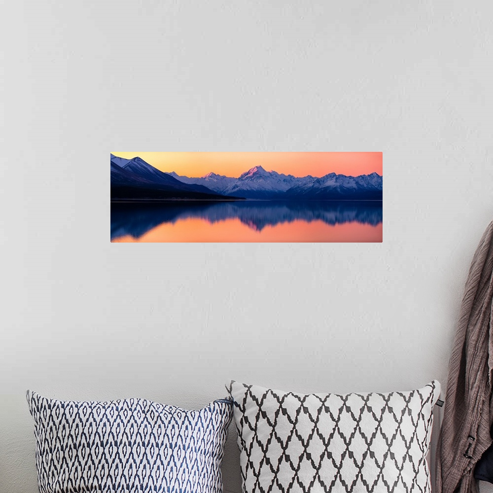 A bohemian room featuring Mount Cook at sunset reflecting in a lake below, New Zealand.