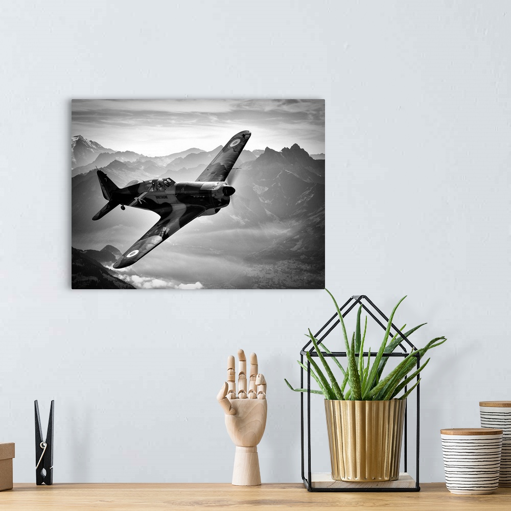 A bohemian room featuring Black and white image of a vintage airplane flying over the Swiss Alps.