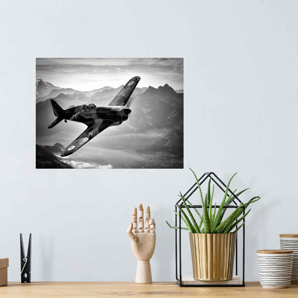 A bohemian room featuring Black and white image of a vintage airplane flying over the Swiss Alps.