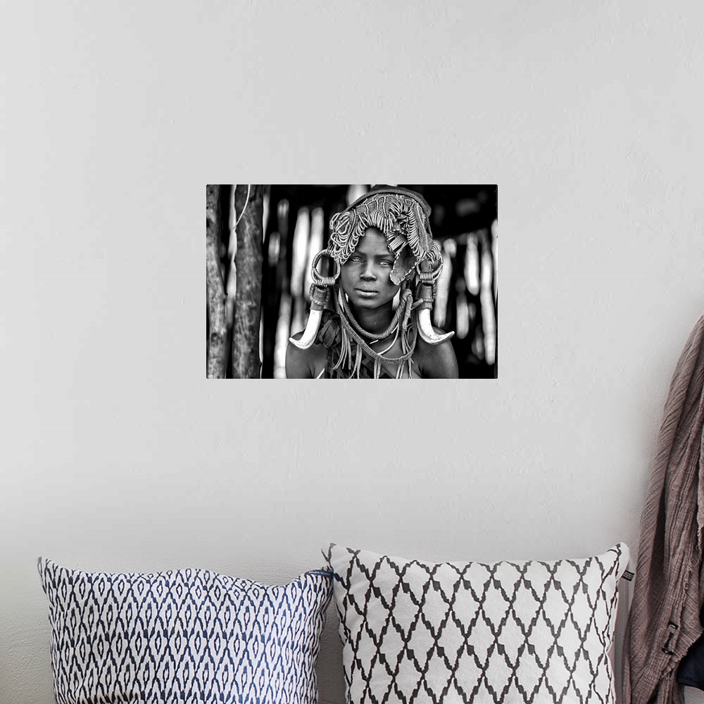 A bohemian room featuring A portrait of a tribeswoman with a unique headdress.