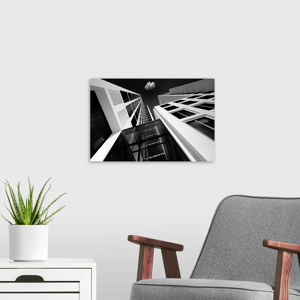 A modern room featuring A black and white photograph looking up at tall skyscrapers in Germany.
