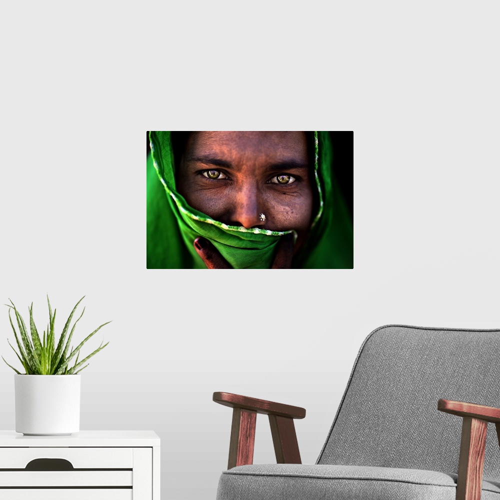A modern room featuring A portrait of a woman with most of her face covered by a green wrap.
