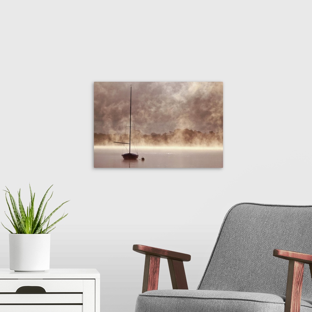 A modern room featuring A boat with a tall mast in a misty lake in Cumbria.
