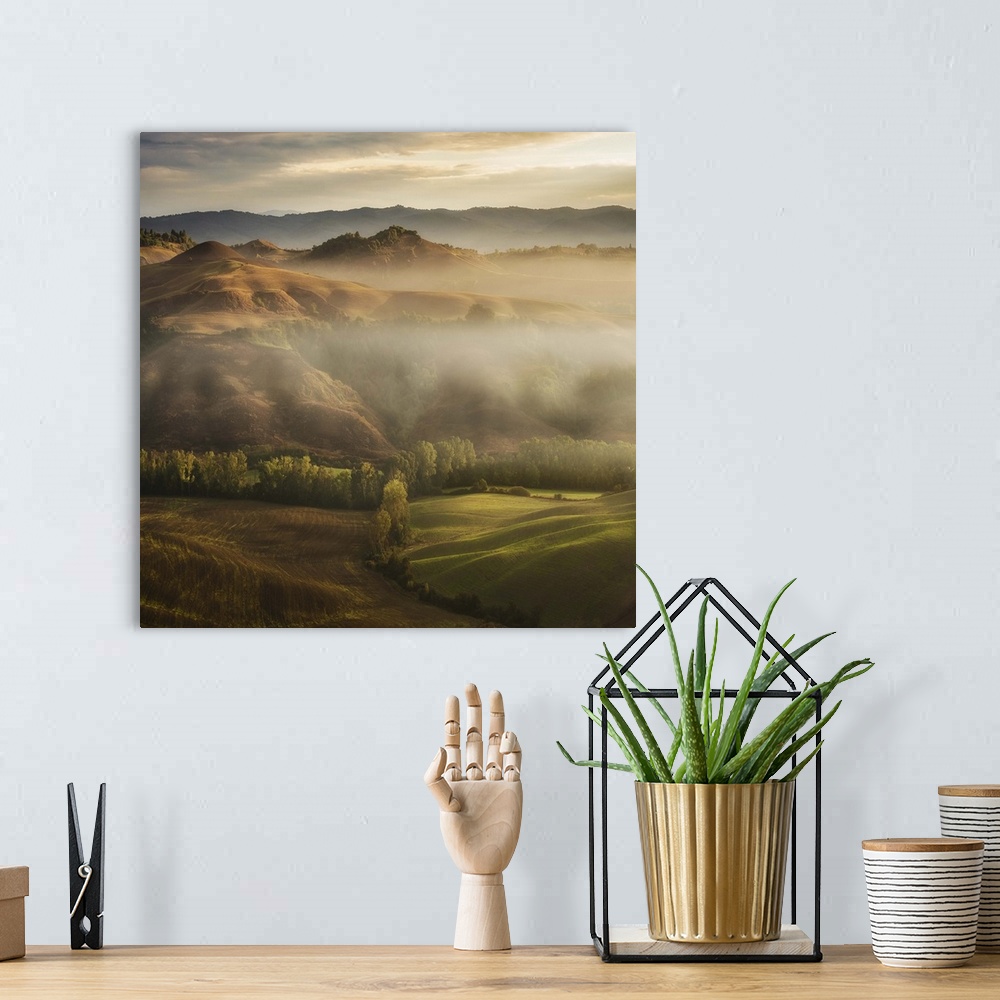 A bohemian room featuring A Tuscan landscape with fog laying in the deep sections of the valley.