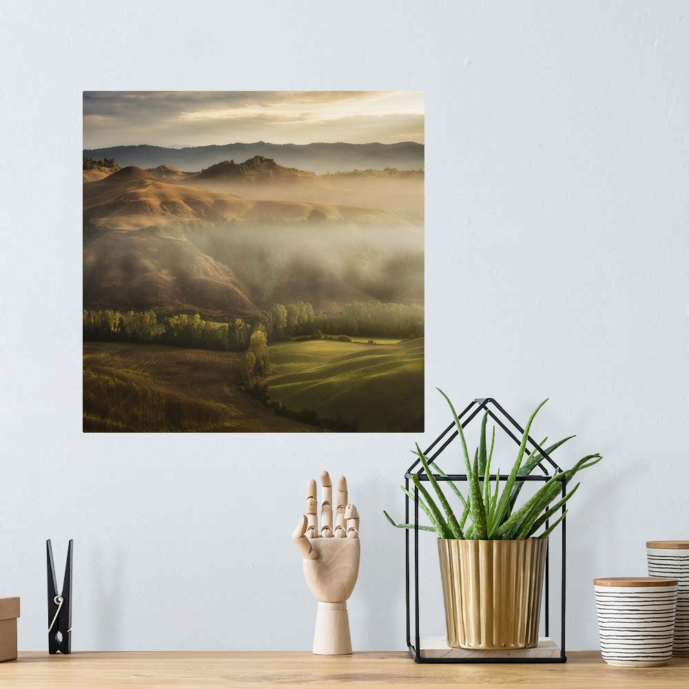 A bohemian room featuring A Tuscan landscape with fog laying in the deep sections of the valley.