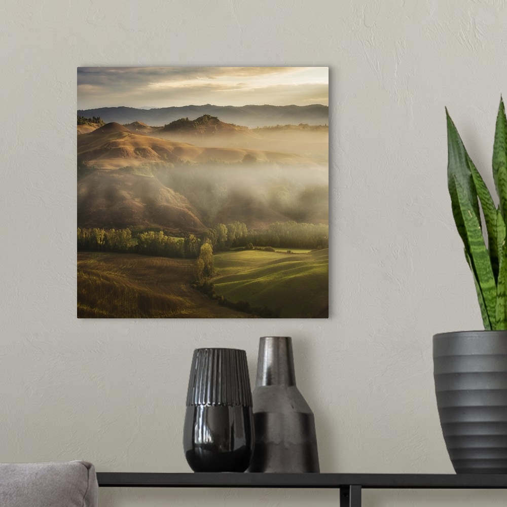 A modern room featuring A Tuscan landscape with fog laying in the deep sections of the valley.