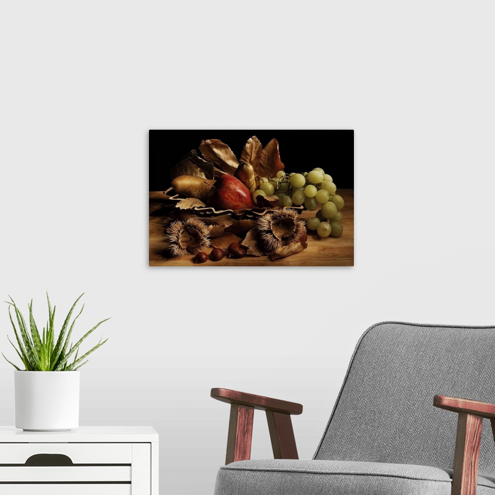 A modern room featuring Still life arrangement with green grapes, a red apple, pears, fallen leaves, and chestnuts with t...