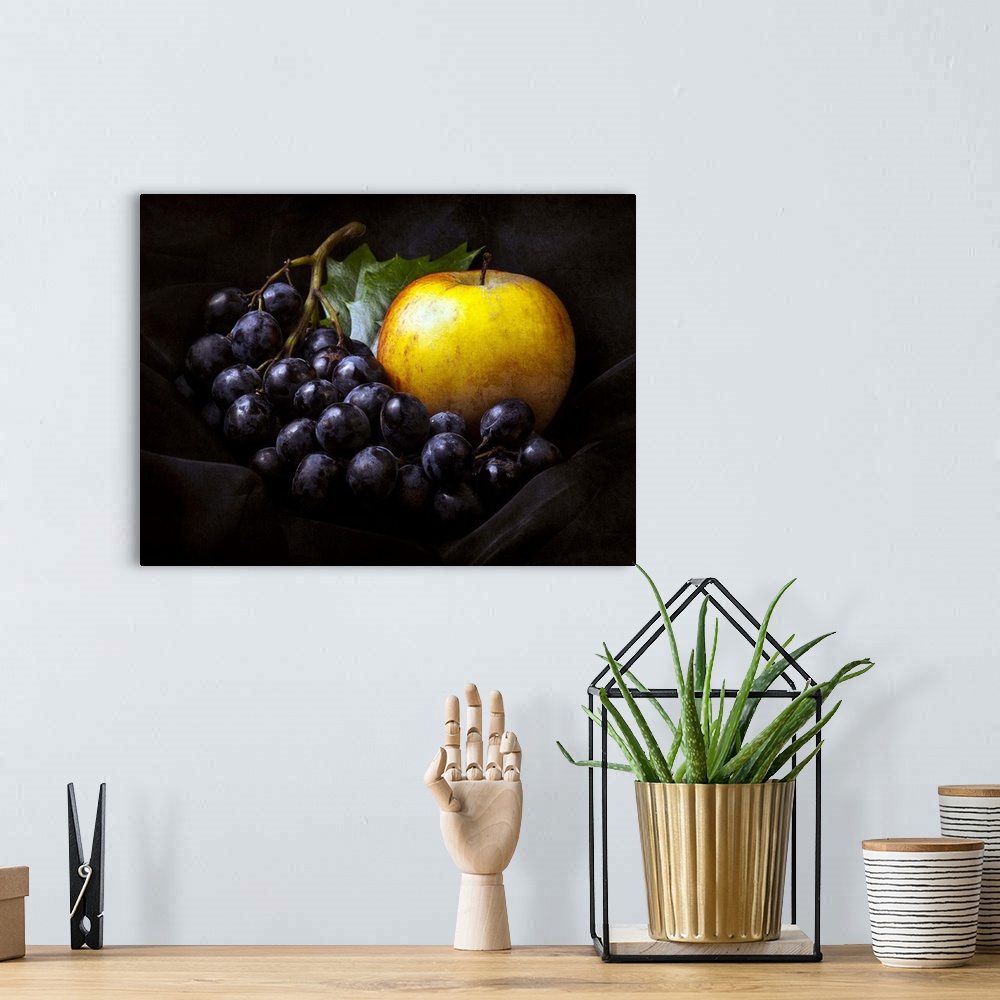 A bohemian room featuring Fine art still life photo of bunch of dark red grapes and a golden apple.