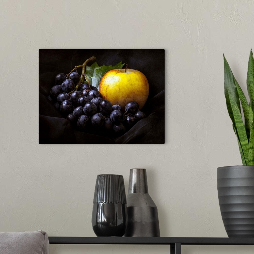A modern room featuring Fine art still life photo of bunch of dark red grapes and a golden apple.