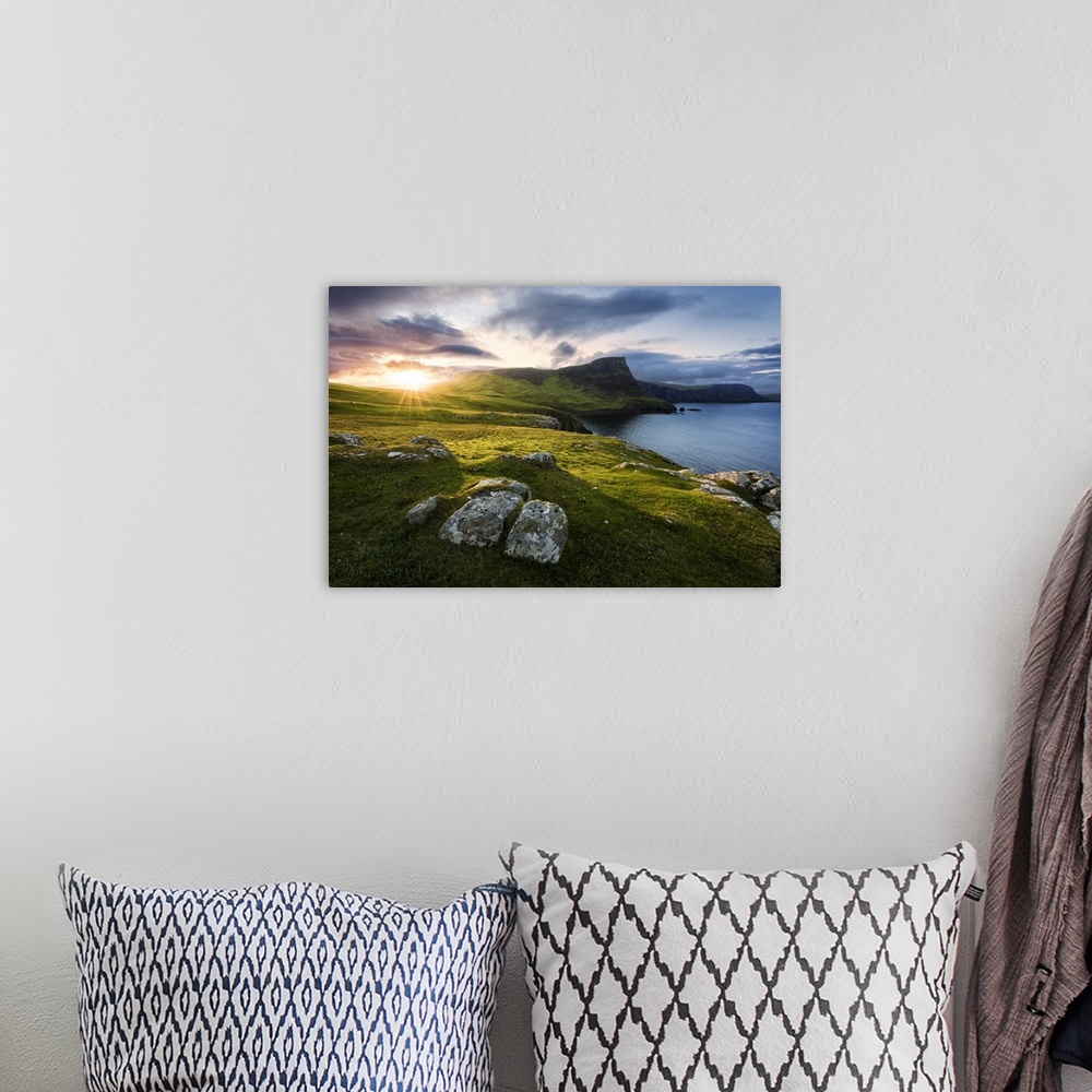 A bohemian room featuring A fine art photograph of a remote coastline in Scotland with the sun setting over the hills