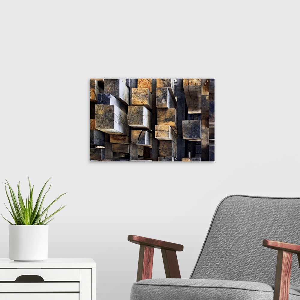 A modern room featuring A stack of rectangular cut logs resembling an aerial shot of skyscrapers in a city. There are eve...