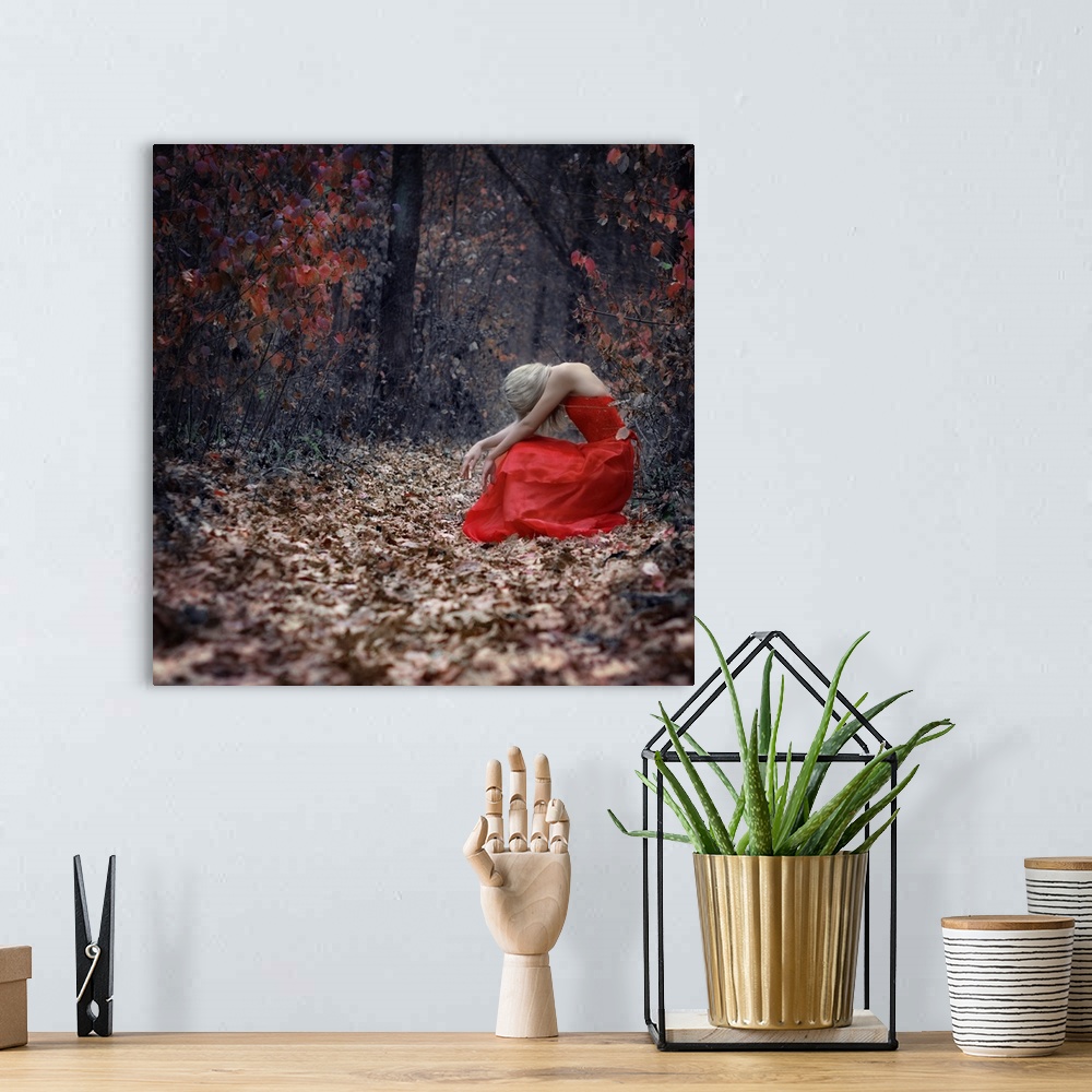 A bohemian room featuring A portrait of a woman with blond hair wearing a red dress, and sitting in a forest surrounded by ...