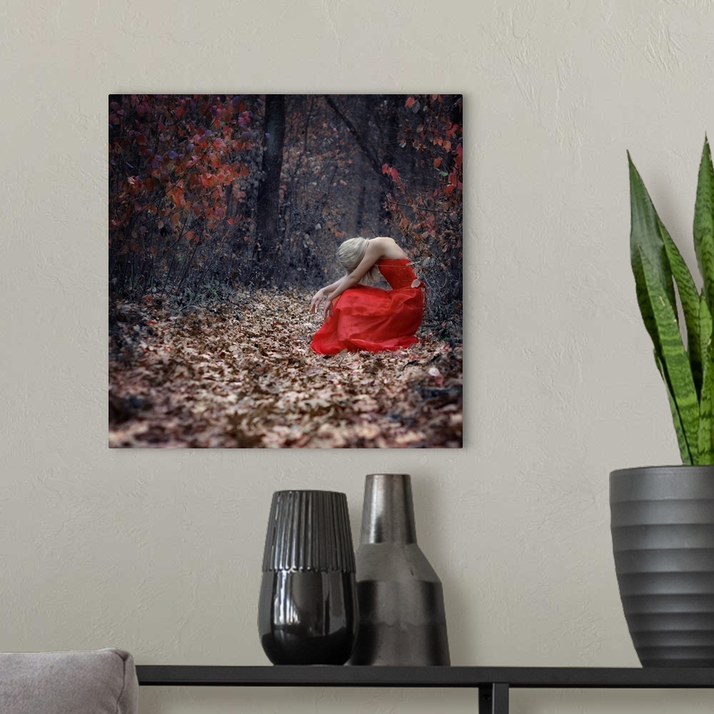 A modern room featuring A portrait of a woman with blond hair wearing a red dress, and sitting in a forest surrounded by ...