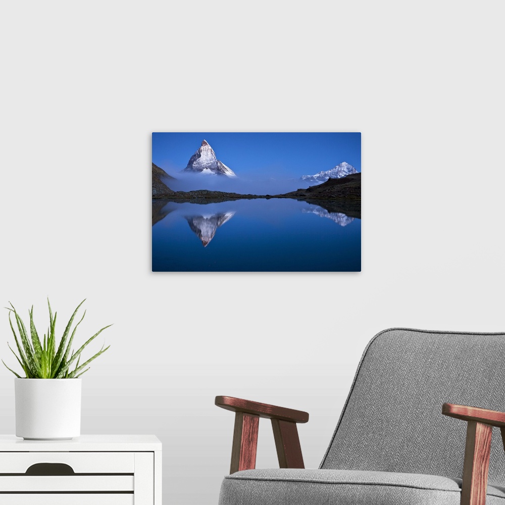A modern room featuring A photograph of the Swiss Alps with the base of the Matterhorn covered in fog.