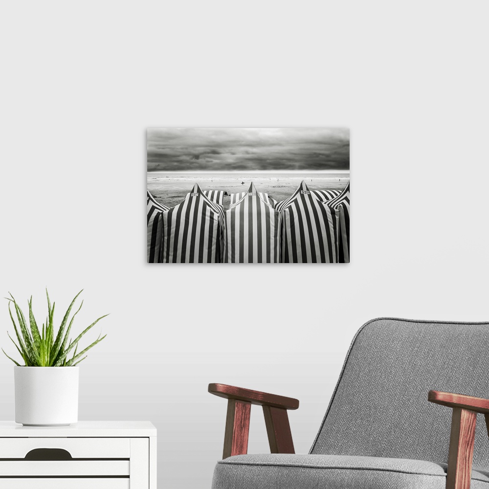 A modern room featuring Black and white photograph of  striped beach tents and the ocean in the background at a beach in ...