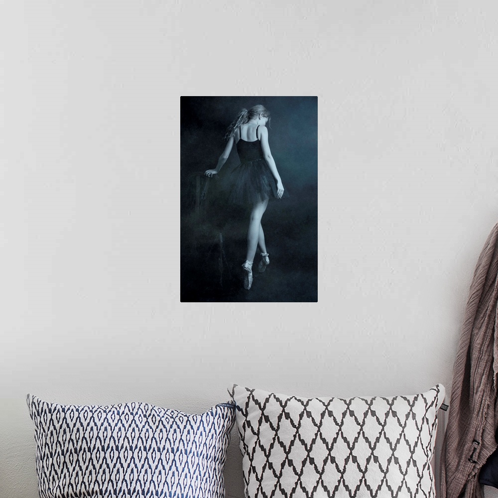 A bohemian room featuring A ballerina in a black dress standing on her toes, with her back turned.