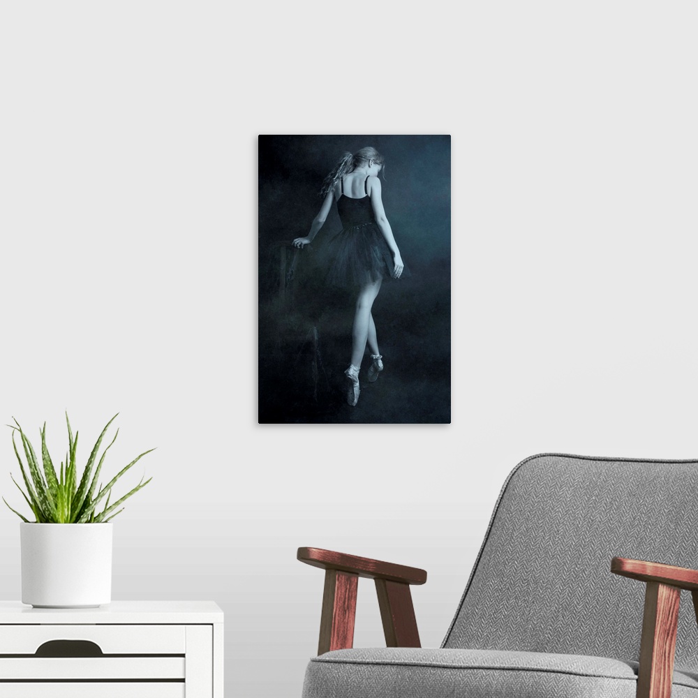 A modern room featuring A ballerina in a black dress standing on her toes, with her back turned.