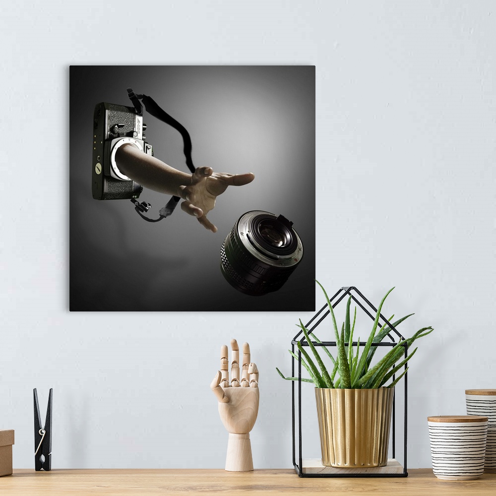 A bohemian room featuring Conceptual image of an arm reaching out of a film camera towards a falling lens.