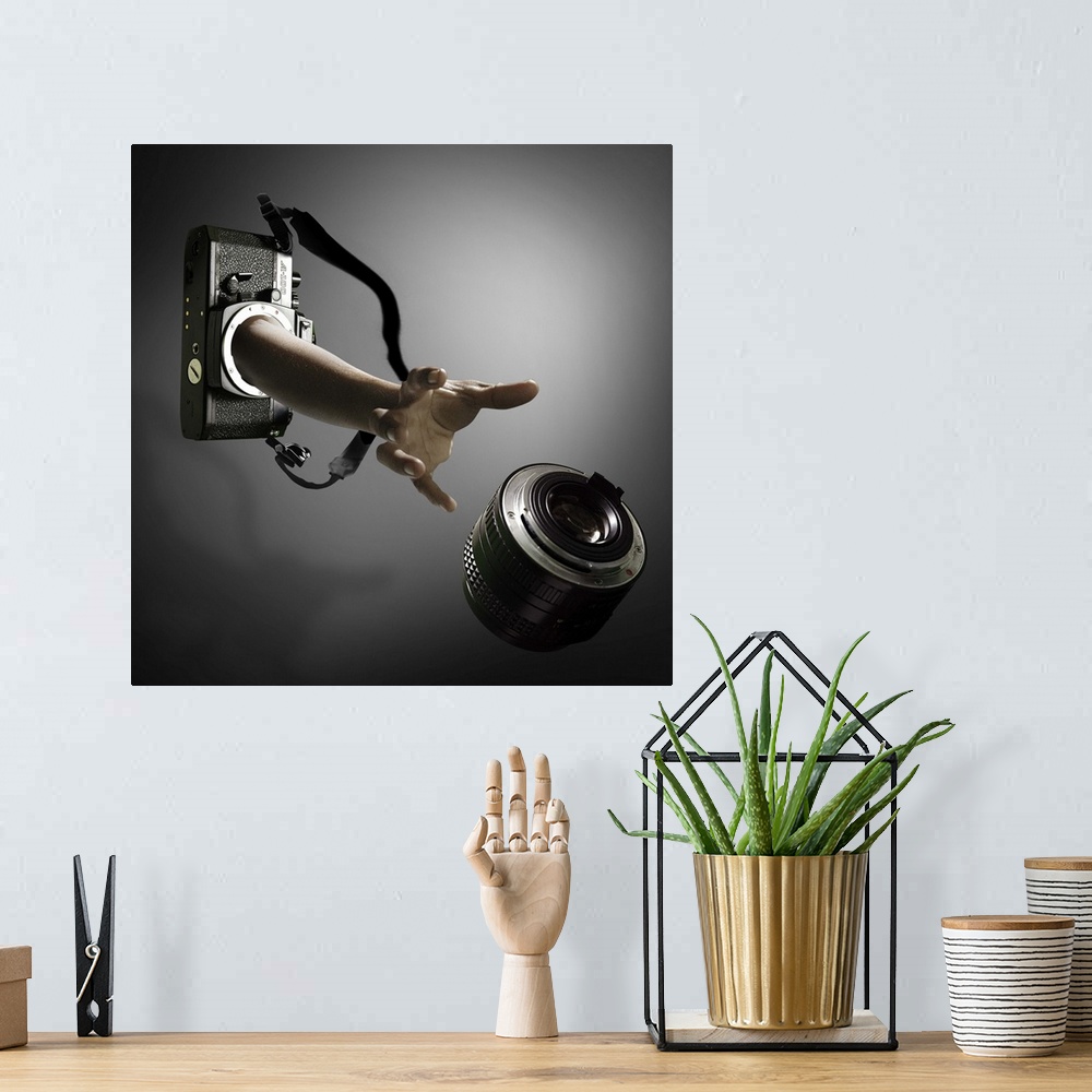 A bohemian room featuring Conceptual image of an arm reaching out of a film camera towards a falling lens.