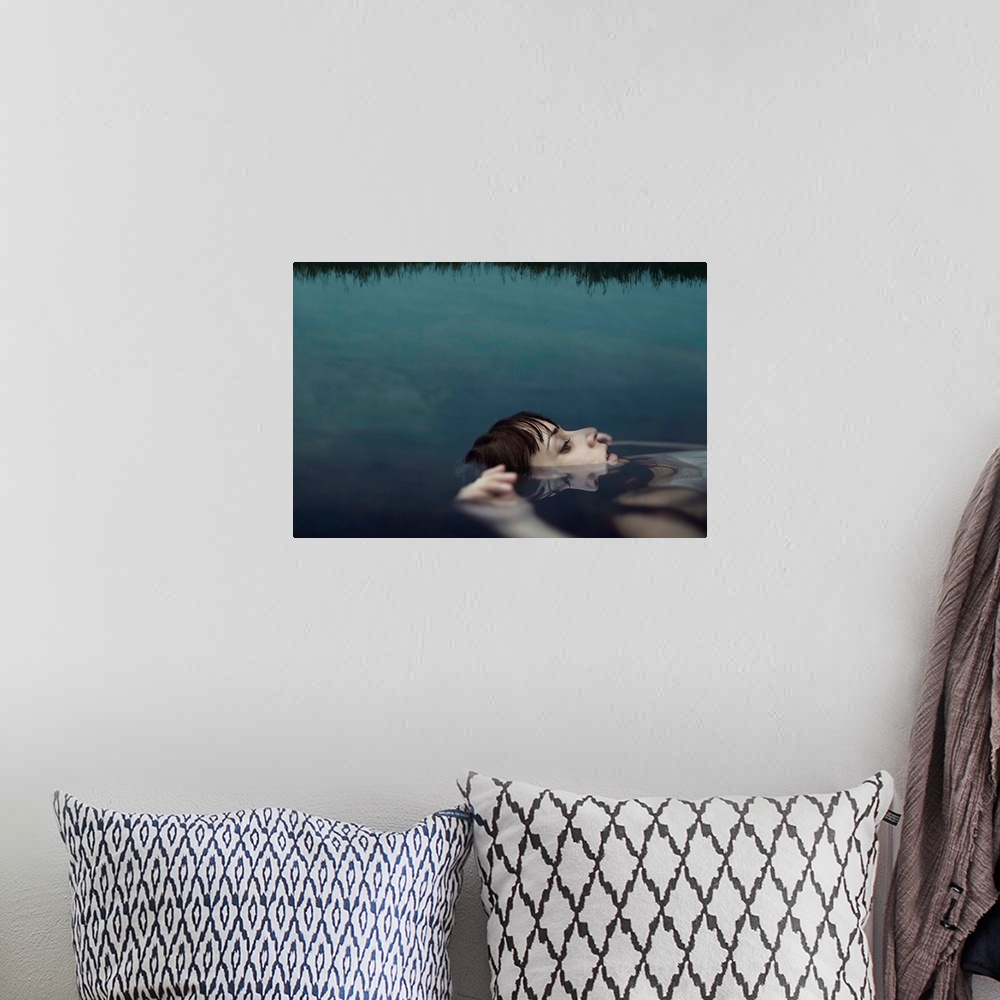 A bohemian room featuring A portrait of a woman wearing a white dress and floating in water with her face above the surface.