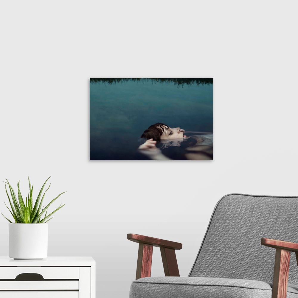 A modern room featuring A portrait of a woman wearing a white dress and floating in water with her face above the surface.