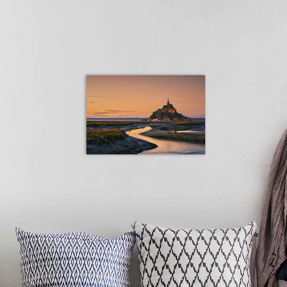 A bohemian room featuring Warm landscape photograph of rivers leading to a castle on top of a hill at sunset.