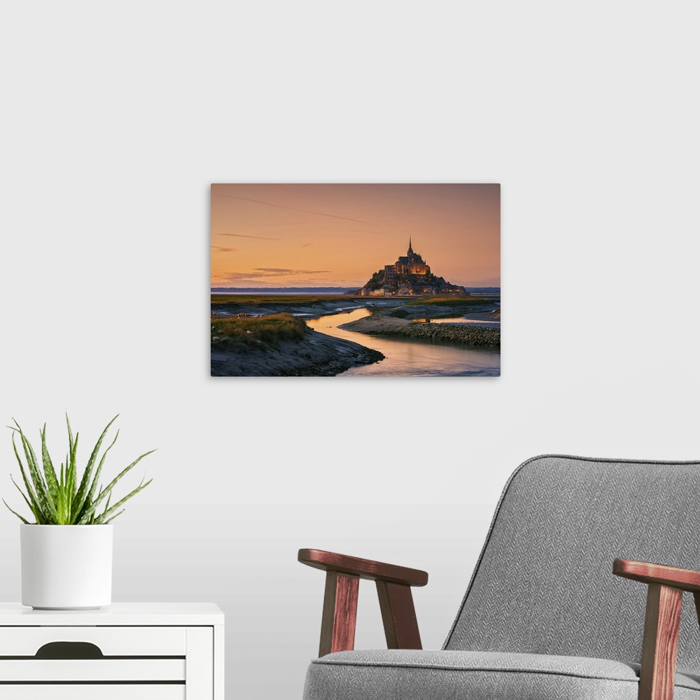 A modern room featuring Warm landscape photograph of rivers leading to a castle on top of a hill at sunset.