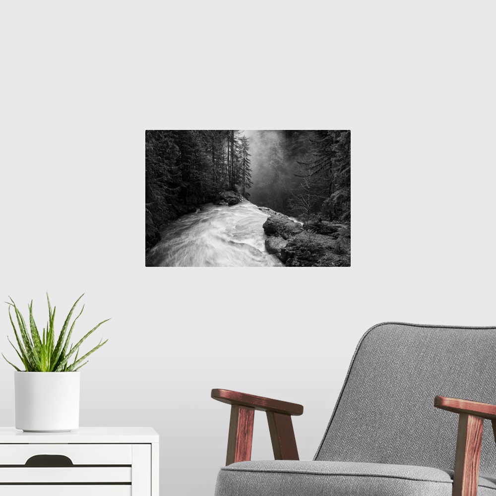 A modern room featuring Nooksack falls flowing over jagged rocks in a forest in Washington.