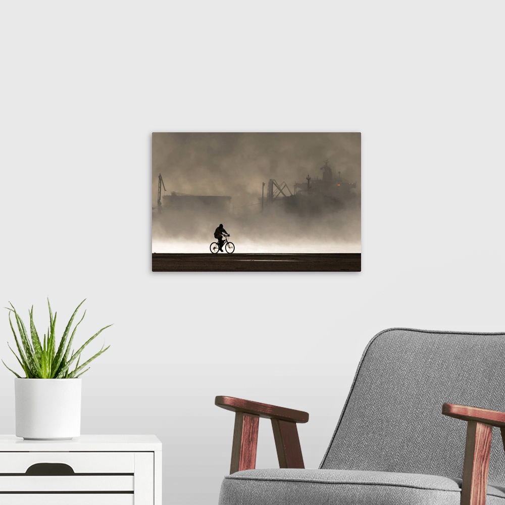 A modern room featuring Silhouette of a cyclist in front of smoke coming from the harbor.